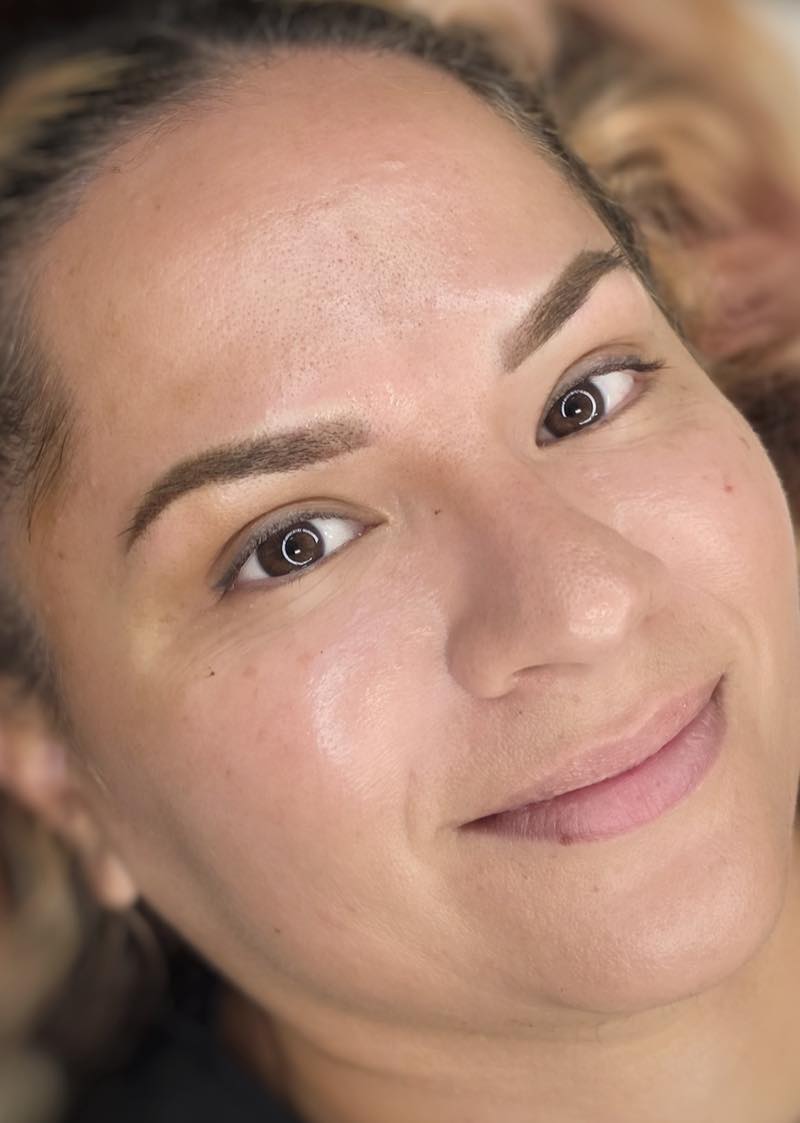 Client smiling with fully healed permanent makeup eyebrows by Brenda Cazares, showing a natural, symmetrical result in National City.
